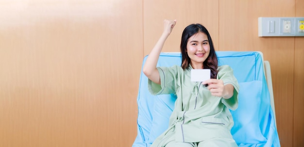 Maquete de cartão branco na asiática Linda mulher paciente sentada na cama do hospital no centro médico