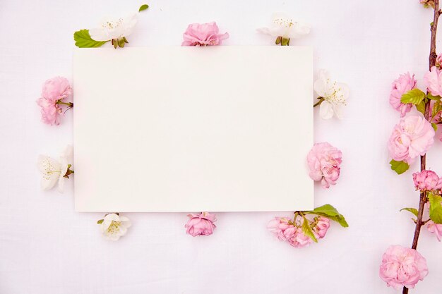 Maquete de cartão de papelaria delicada com flores brancas e rosa de primavera Convite de aniversário de casamento romântico dia das mães mock up conceito de cartão Copie o espaço Vista de cima