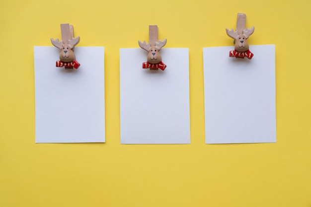 Maquete de cartões em branco de natal em prendedores de roupa papai noel em um fundo amarelo com lugar para o conceito de texto natal e ano novo