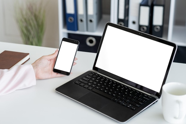 Foto maquete de computador de mulher de escritório de publicidade digital mão feminina segurando smartphone e laptop com