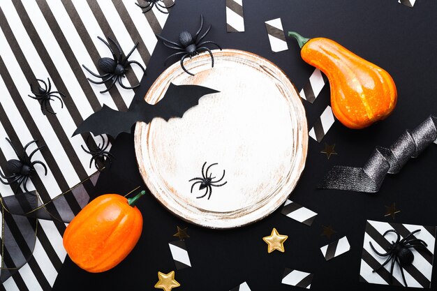 Maquete de convite de festa de halloween, celebração. conceito de decorações de halloween com morcegos, aranhas, abóboras, estrelas, confetes, fita. camada plana, vista superior, copie o espaço em fundo preto e branco.