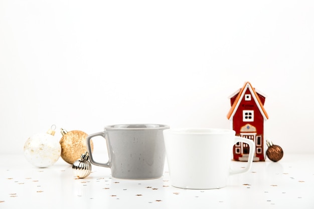 Maquete de copo vazio branco e cinza sobre fundo claro com maquete de caneca minimalista de decorações de natal