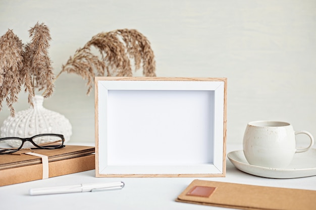 Foto maquete de desktop minimalista estilizado com cor orgânica estacionária, xícara de café, moldura