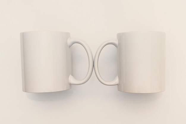 Maquete de duas canecas de cerâmicas brancas em um fundo branco Conceito de café da manhã