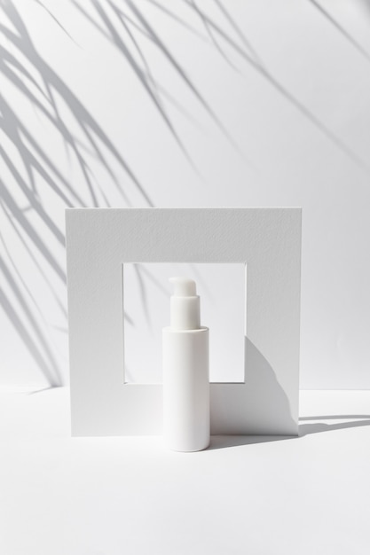 Maquete de frasco cosmético com creme ou soro em fundo branco. Modelo de conceito de beleza skincare. Luz natural forte, sombras profundas em fundo branco.