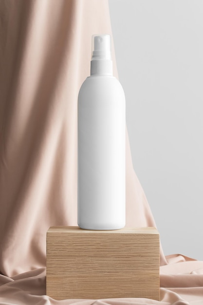 Maquete de frasco de spray cosmético branco com tecido bege