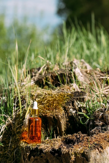 maquete de garrafa com conta-gotas no fundo da natureza