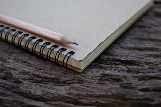 Foto maquete de lápis e livro na velha mesa de madeira, close-up