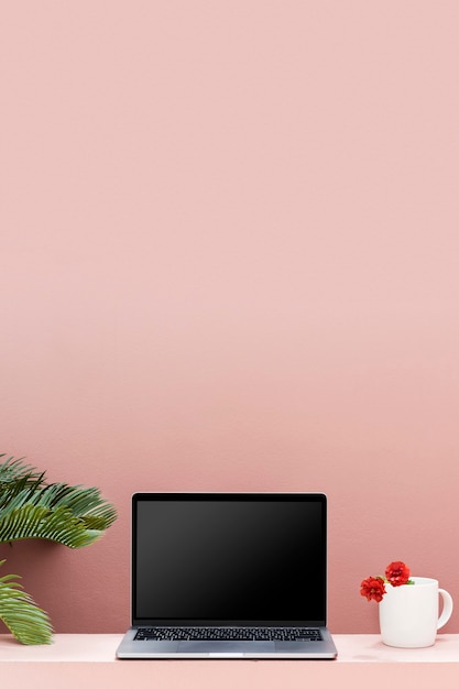 Maquete de laptop com parede rosa pastel
