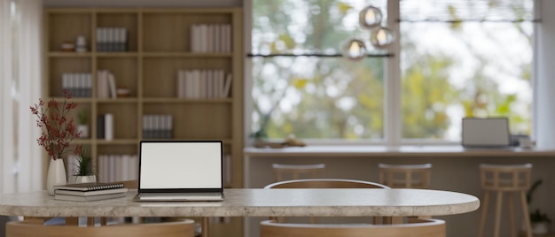 Maquete de laptop e espaço de cópia em uma mesa em uma sala de coworking confortável e mínima