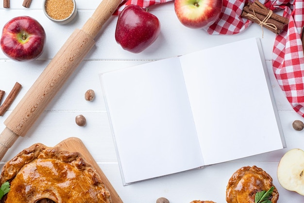Foto maquete de livro de culinária aberta em branco com torta de carne de torta de maçã e frutas da estação