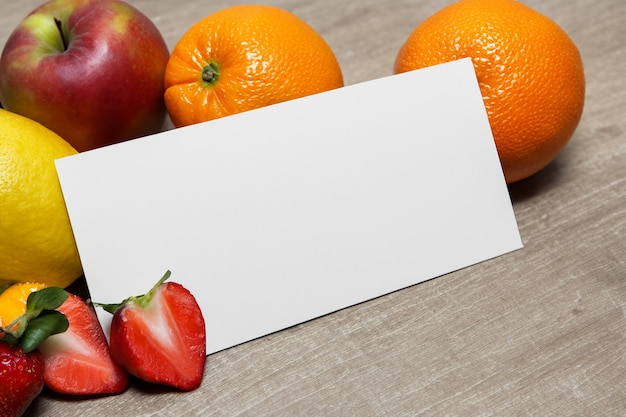 Maquete de papel branco aprimorada com frutas frescas, criando um banquete visual de design saudável e vibrante