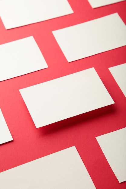Maquete de pilhas horizontais de cartões de visita organizadas em linhas no fundo do papel vermelho