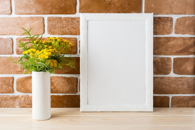 Maquete de quadro branco com flores amarelas perto de paredes expostas