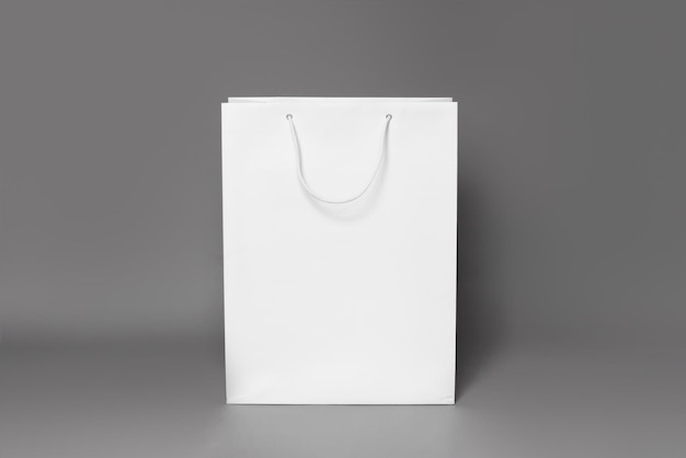 Maquete de sacola de compras branca isolada sobre fundo de papel cinza escuro. visão direta