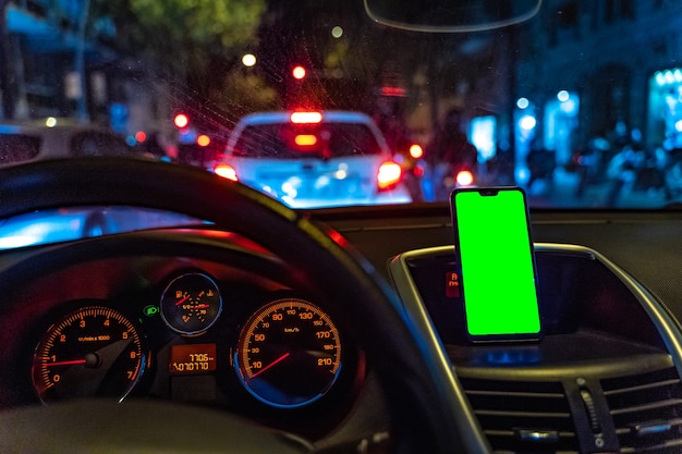 Maquete de smartphone com tela verde no carro enquanto dirige para adicionar GPS ou aplicativo