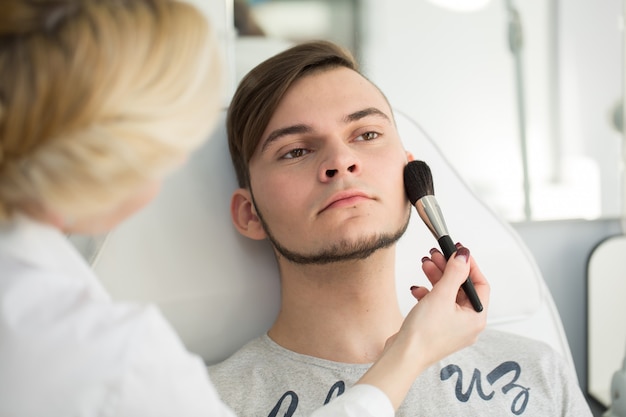 Maquiador profissional, maquiagem de jovem em estúdio