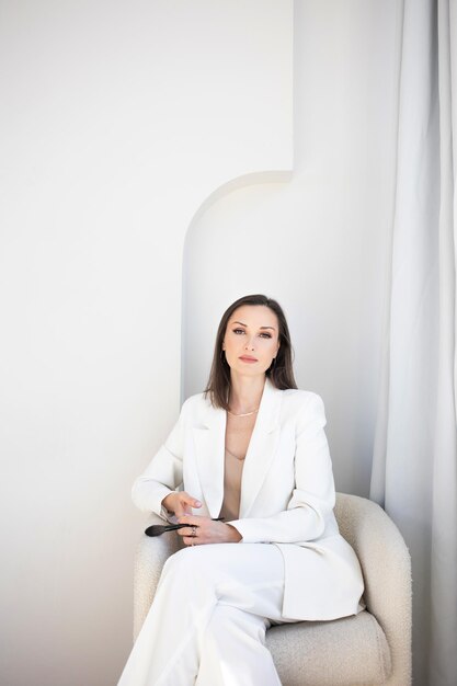 Foto maquiadora elegante de moda e beleza em uma jaqueta branca com pincéis de maquiagem em seu negócio de mãos