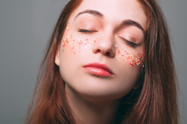 Maquiagem com glitter. Pele perfeita e fresca. Beleza da juventude da mulher. Mulher muito sonhadora. Olhos fechados.