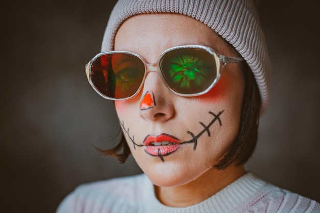 Maquiagem de hipster de halloween horrível descarada com óculos e chapéu pintado cicatriz de boca moda moderna