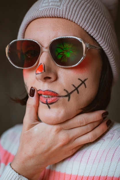 Maquiagem de hipster de halloween horrível descarada com óculos e chapéu pintado cicatriz de boca moda moderna