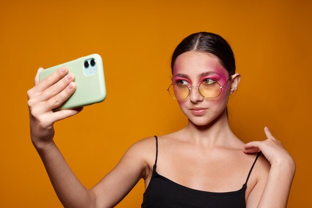Maquiagem de rosto rosa de mulher morena sexy posando um olhar atraente selfie isolado fundo inalterado