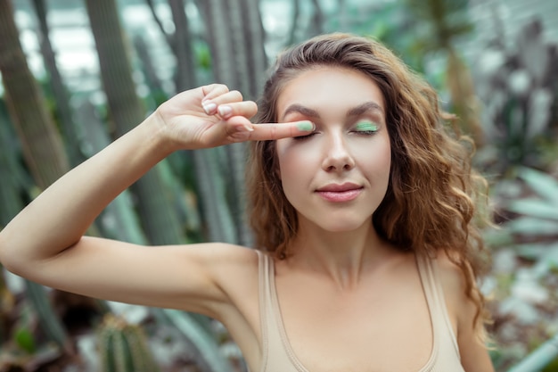 Maquiagem. Mulher bonita colocando sombras nas pálpebras