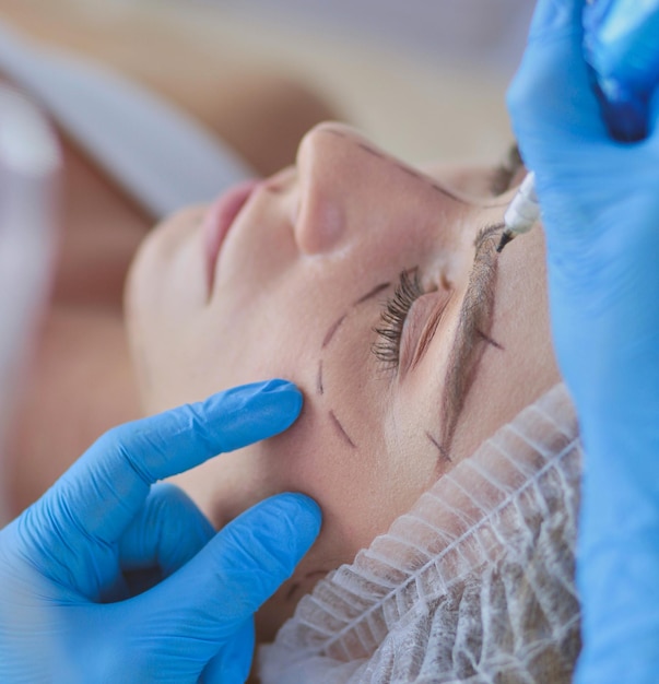 Maquiagem permanente para sobrancelhas Closeup de mulher bonita com sobrancelhas grossas no salão de beleza