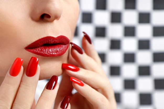 Maquiagem vermelha e manicure em uma garota closeup