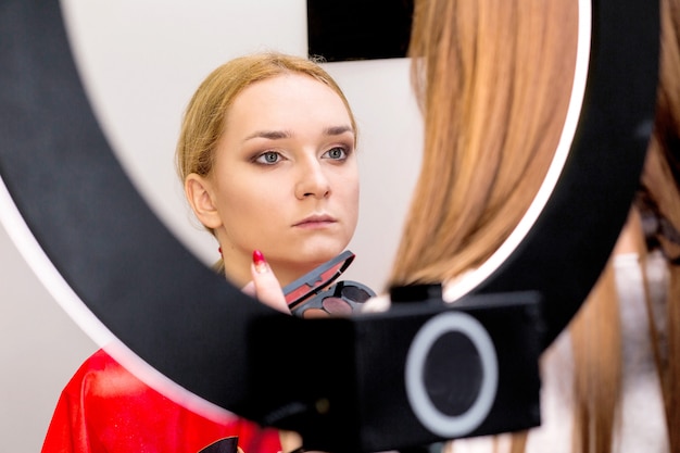 Maquilladora hace maquillaje para la modelo