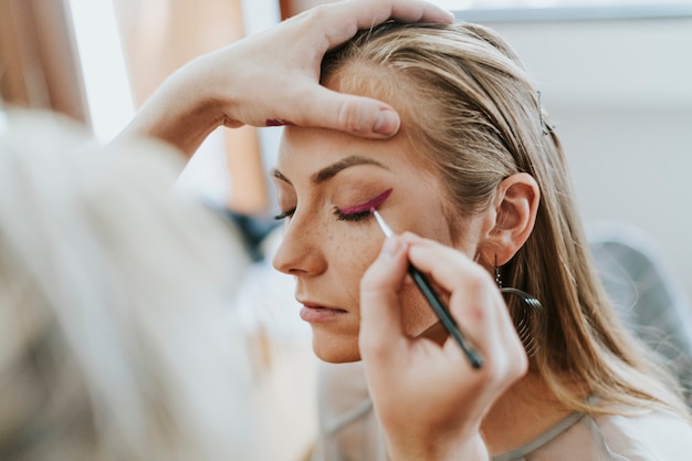 Maquilladora haciendo un delineador para la modelo.