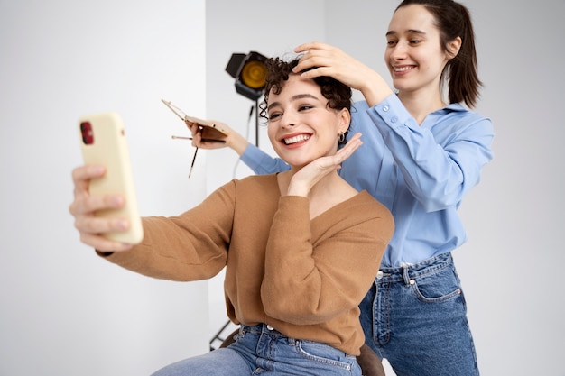 Foto maquilladora preparando modelo para sesión de fotos