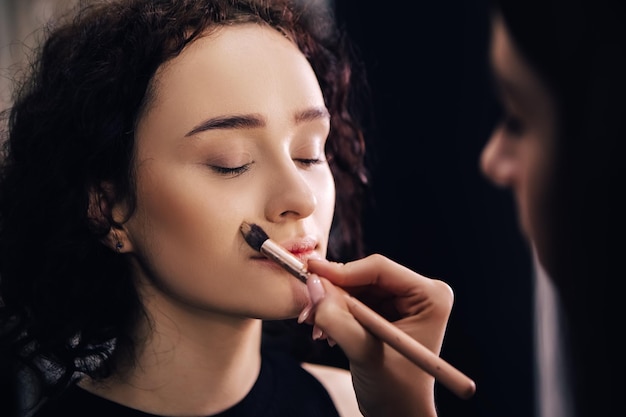 Maquilladora talentosa haciendo maquillage a mujer