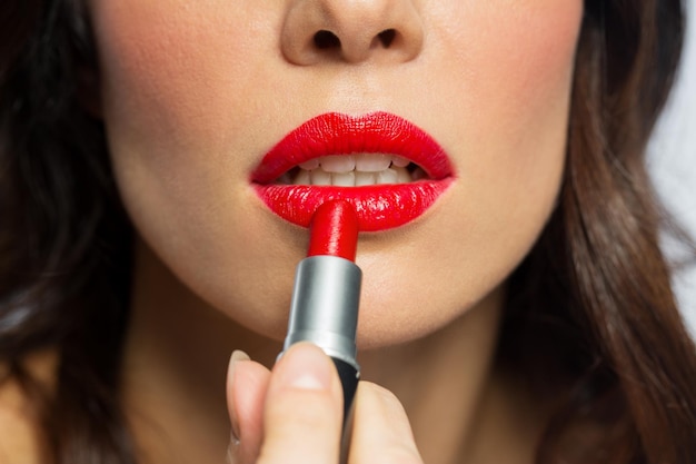 maquillaje de belleza y cosméticos concepto de primer plano de la cara de la mujer aplicando lápiz labial rojo a sus labios