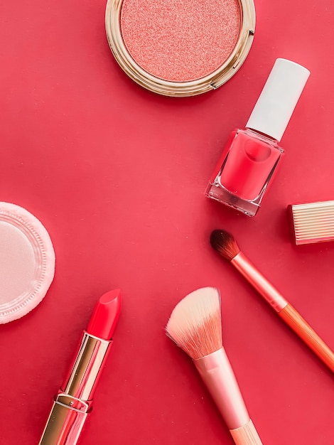 Maquillaje de belleza y diseño plano de cosméticos con productos cosméticos copyspace y herramientas de maquillaje sobre fondo de coral concepto de estilo femenino y femenino