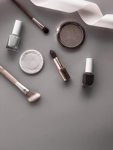 Maquillaje de belleza y diseño plano de cosméticos con productos cosméticos copyspace y herramientas de maquillaje sobre fondo gris estilo femenino y femenino