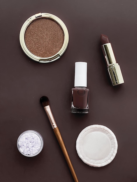 Maquillaje de belleza y diseño plano de cosméticos con productos cosméticos copyspace y herramientas de maquillaje sobre fondo marrón estilo femenino y femenino