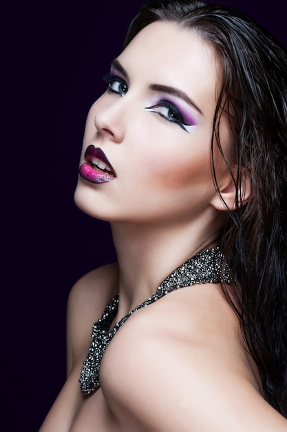 Foto maquillaje de belleza. maquillaje morado y uñas brillantes de colores