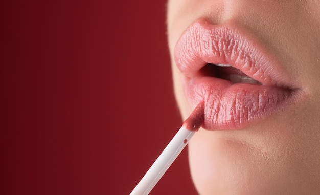 Maquillaje brillante de lápiz labial rojo para labios carnosos y naturales lápiz labial y pomada de cerca labios rojos rosa