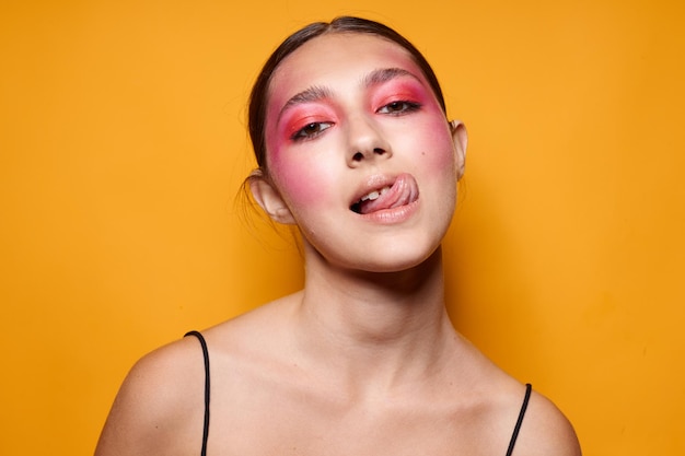 Maquillaje de cara rosa de mujer de moda posando aspecto atractivo fondo amarillo inalterado