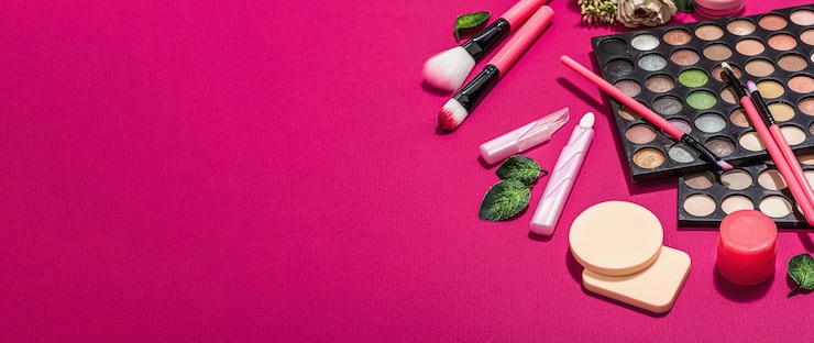 Foto maquillaje con coloridas paletas de sombras de ojos, pinceles, esponjas y flores trendy viva magenta color background spring festivo cosmetic concept flat lay banner format