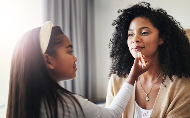 Maquillaje feliz y pintalabios con madre e hija para vincularse jugando y afectivamente Cuidar la felicidad y relajarse con una mujer negra y un niño en el hogar familiar para cosméticos relajarse y arreglarse