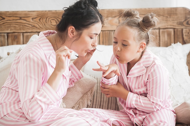 Maquillaje de madre e hija juntas. Pequeñas cosas de niña. Ocio femenino.