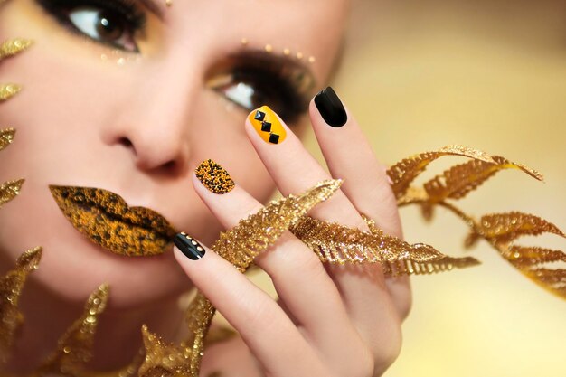 Maquillaje y manicura en negro y amarillo.