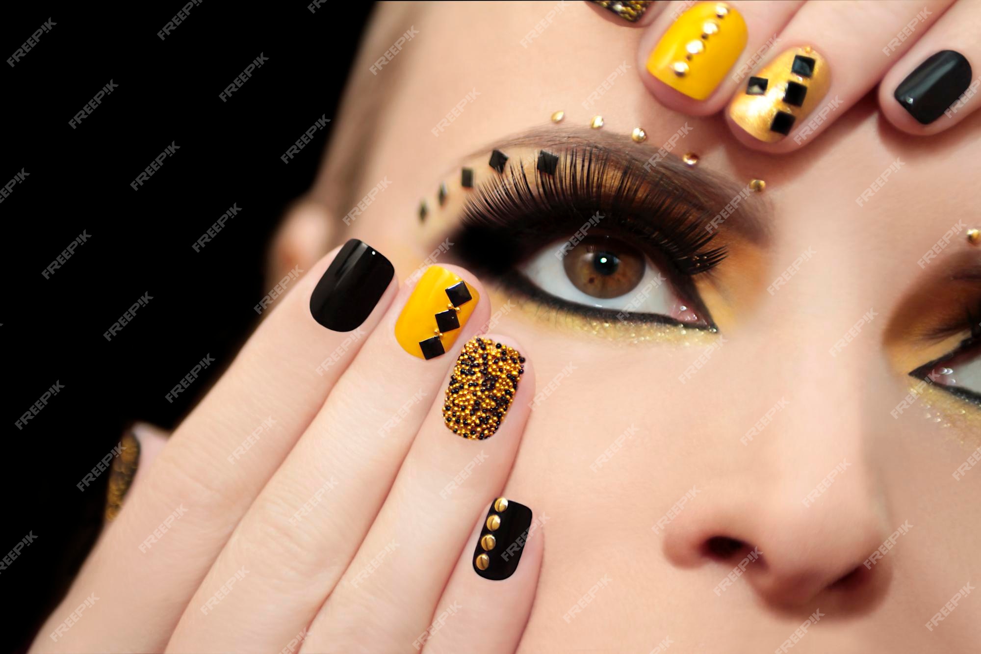 Maquillaje y manicura en negro y amarillo. | Foto Premium
