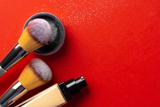 Maquillaje productos y cosméticos sobre fondo rojo. De cerca.