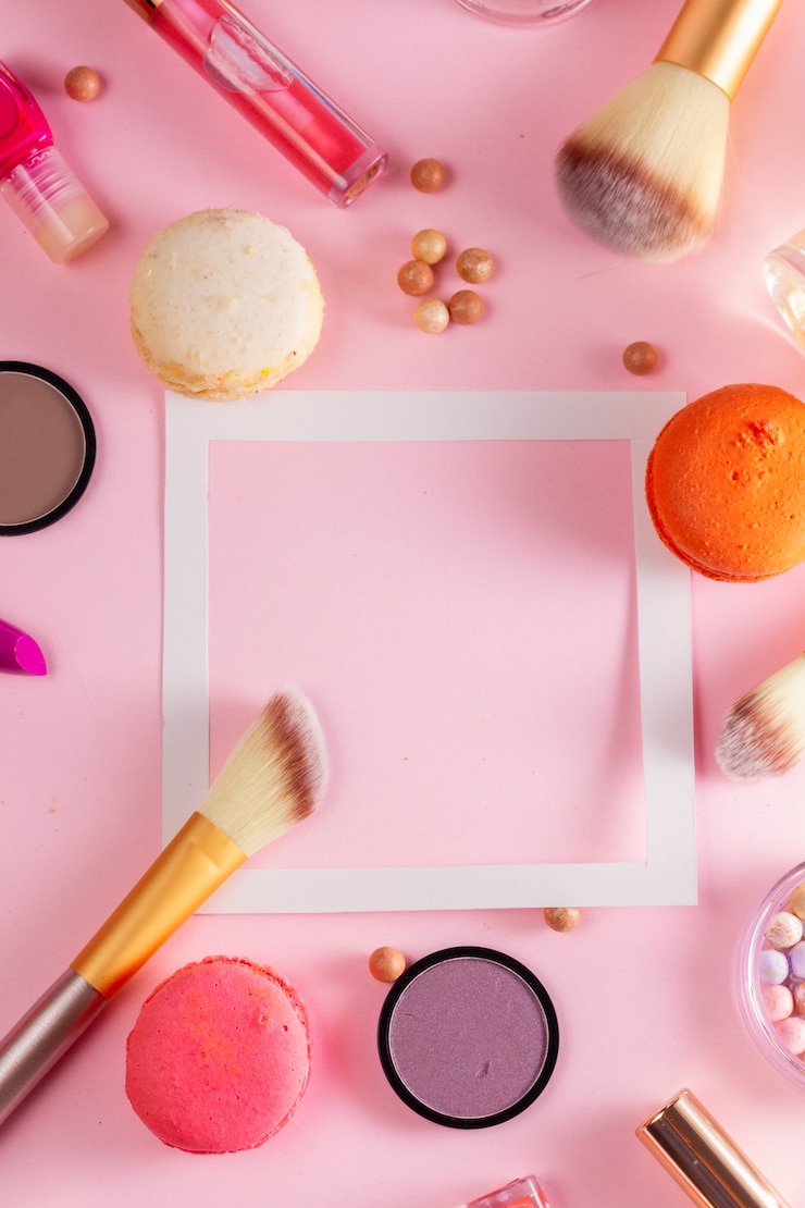 Foto maquillaje productos y macarrones aislados en rosa