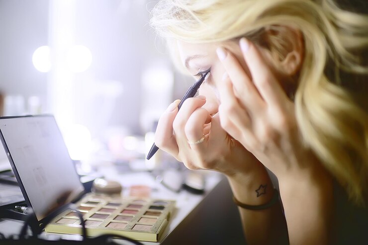 Foto maquillaje profesional en el salón de belleza / maestro hace un maquillaje profesional de verano fresco de una hermosa modelo en el salón