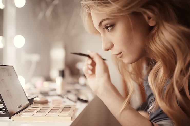 Foto maquillaje profesional en el salón de belleza / maestro hace un maquillaje profesional de verano fresco de una hermosa modelo en el salón