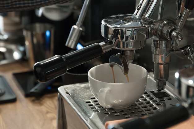 La máquina de café en la cafetería hace un capuchino, enfoque selectivo.